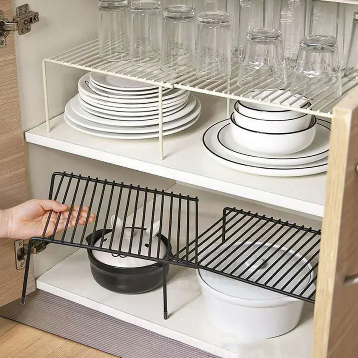 Expandable shelf organizing dishes in a wooden cabinet